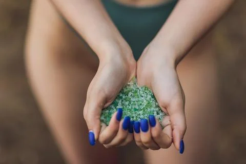 Tiny pieces of plastic collected from sandy beach in hands of environmentalist Foto stock