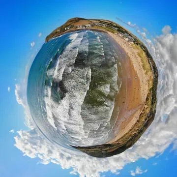 Tiny planet of Croyde beach in Devon with surfers in the swell below the drone Stock Photos