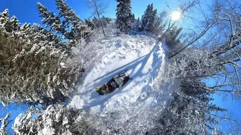 Tiny planet extreme wide angle looking down onto a snowmobile that is moving  Stock Footage 233224959