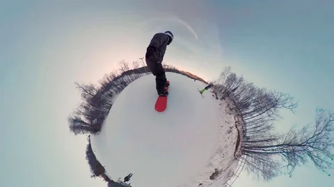 Tiny planet following snowboarder on ski hill Stock Footage 84661141