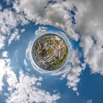 Tiny planet in sky with clouds overlooking old town, urban development, histo Stock Photos