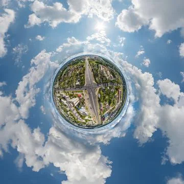 Tiny planet in sky with clouds overlooking old town, urban development, histo Stock Photos