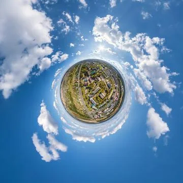 Tiny planet in sky with clouds overlooking old town, urban development, histo Stock Photos