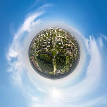 Tiny planet in sky with clouds overlooking old town, urban development, histo Stock Photos