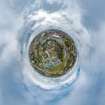 Tiny planet in sky with clouds overlooking old town, urban development, histo Stock Photos