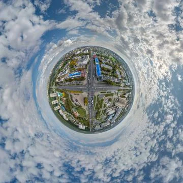 Tiny planet in sky with clouds overlooking old town, urban development, histo Stock Photos