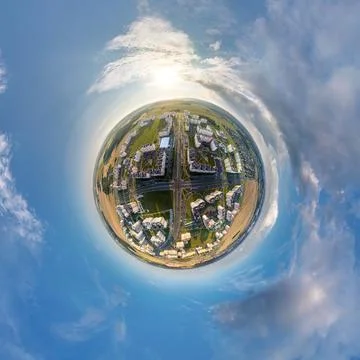 Tiny planet in sky with clouds overlooking old town, urban development, histo Stock Photos