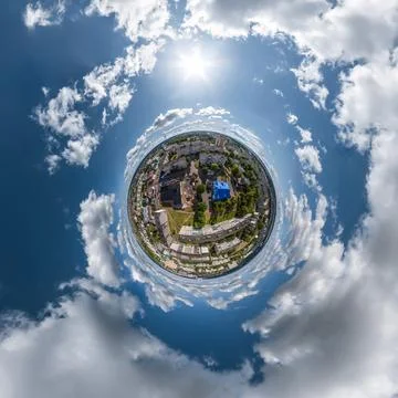 Tiny planet in sky with clouds overlooking old town, urban development, histo Stock Photos