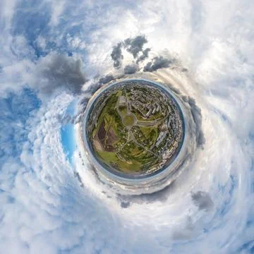 Tiny planet in sky with clouds overlooking old town, urban development, histo Stock Photos