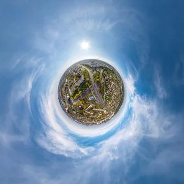 Tiny planet in sky with clouds overlooking old town, urban development, histo Stock Photos