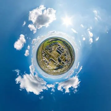 Tiny planet in sky with clouds overlooking old town, urban development, histo Stock Photos