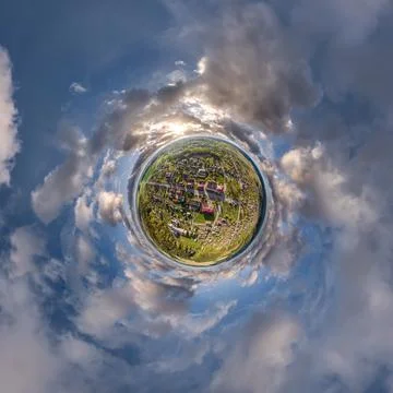 Tiny planet in sky with clouds overlooking old town, urban development, histo Stock Photos