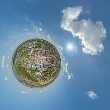 Tiny planet in sky with clouds overlooking old town, urban development, histo Stock Photos