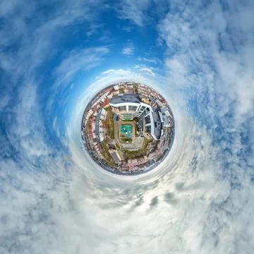 Tiny planet in sky with clouds overlooking old town, urban development, histo Stock Photos