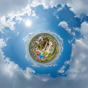 Tiny planet in sky with clouds overlooking old town, urban development, histo Stock Photos