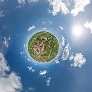 Tiny planet in sky with clouds overlooking old town, urban development, histo Stock Photos