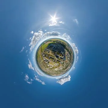 Tiny planet in sky with clouds overlooking old town, urban development, histo Stock Photos