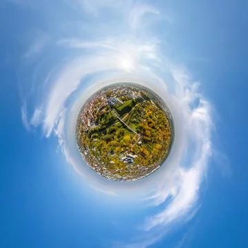 Tiny planet in sky with clouds overlooking old town, urban development, histo Stock Photos