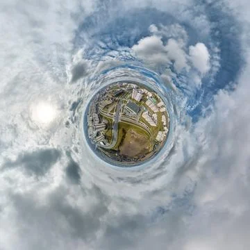 Tiny planet in sky with clouds overlooking old town, urban development, histo Stock Photos