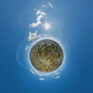 Tiny planet in sky with clouds overlooking old town, urban development, histo Stock Photos