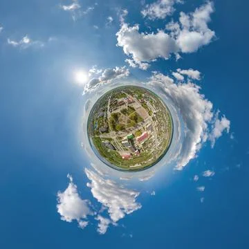 Tiny planet in sky with clouds overlooking old town, urban development, histo Stock Photos