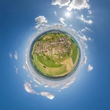 Tiny planet in sky with clouds overlooking old town, urban development, histo Stock Photos