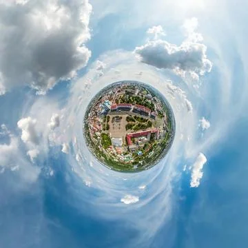 Tiny planet in sky with clouds overlooking old town, urban development, histo Stock Photos