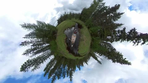A tiny planet style video looking down on two people paddling a canoe  Stock Footage 285889192