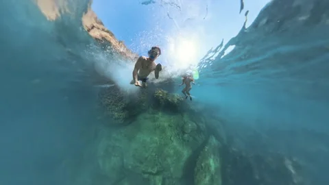 Tiny planet. Underwater shot of a man diving from a cliff into the depths, as he Video stock 288297236