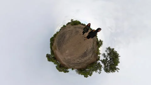 A tiny planet view featuring a man and a woman walking on sandy terrain with 스톡 동영상 293086231