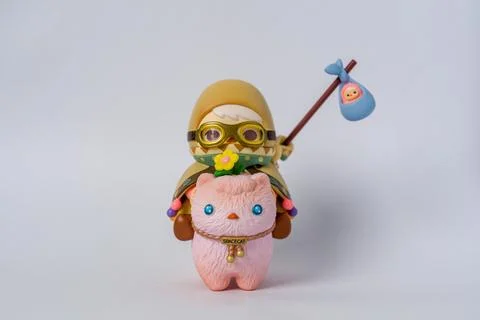 Tiny plush creature wears goggles and holds a stick Stock Photos
