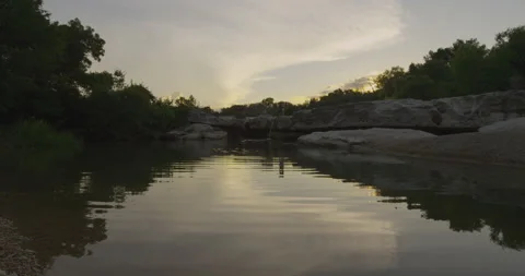 A tiny pond with a stone wall at dusk Stock Footage 149350312