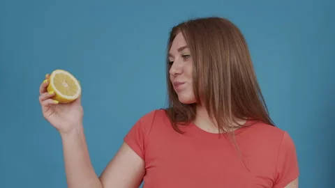 Tiny, red-haired girl with peace of lemon in her hands Stock Footage 145439685