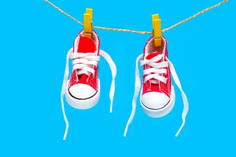 Tiny Red High-Top Canvas Shoes on a Clothesline Foto stock