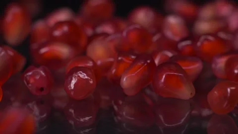 Tiny red jewels. Super slow motion shot of pomegranate seeds falling and rolling Stock Footage 147411700