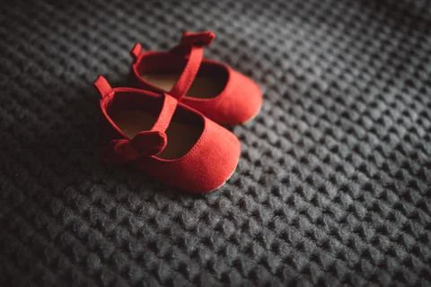 Tiny red shoes on grey blanket Stock Photos