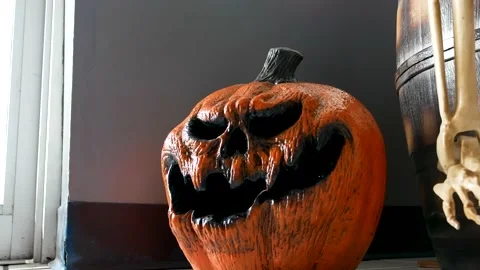 A tiny scary pumpkin sits next to a door, halloween decoration concept Stock Footage 167625487