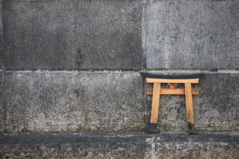 Tiny Shinto shrine torii gate up on a concrete wall 스톡 사진