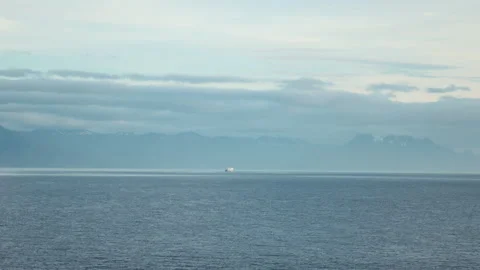 Tiny ship on the horizon below snowy mountains in Alaska Video stock 348016618