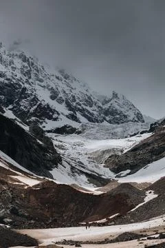 Tiny silhouettes of people against the backdrop of the Chalaadi glacier in .. Stock Photos