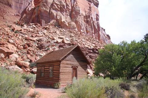 The tiny small Fruita Schoolhouse with the red rock cliff on the back Stock Photos