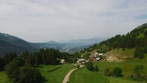 Tiny small village in the mountains in summer. Path is leading through the field Stock Footage 123972227