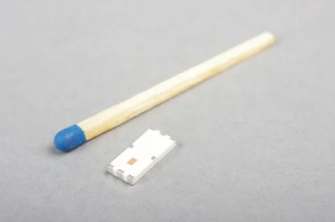 Tiny SMD chip antenna in comparison with match head isolated Stock Photos