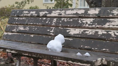 Tiny snowman on an old bench in a park. Stock Footage 218892790