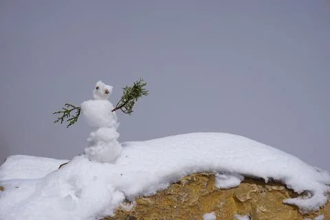 Tiny Snowman on Snow Covered Stone Stock Photos