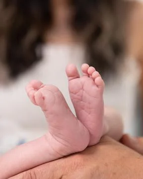 Tiny soles and heels of her baby. Stock Photos