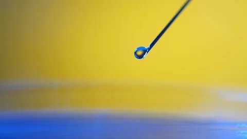 Tiny transparent drops come down from a metallic needle on glass in a lab Stock-Footage 87646640