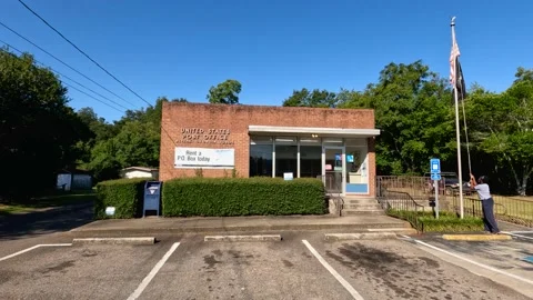 Tiny United States Post office small town USA employee adjusting flags outsid Video stock 221281683