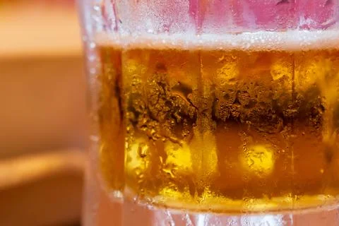 Tiny water droplets condense on a beer glass meant to cool you down in the .. Stock Photos