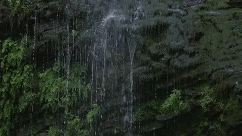 Tiny waterfall running over stones.Creative. Small drops of water flowing from Stock Footage 186730637